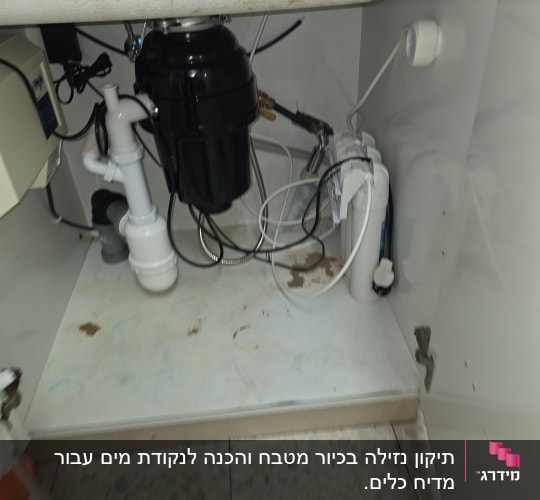 מתחת לכיור עם צנרת ומכשירים
